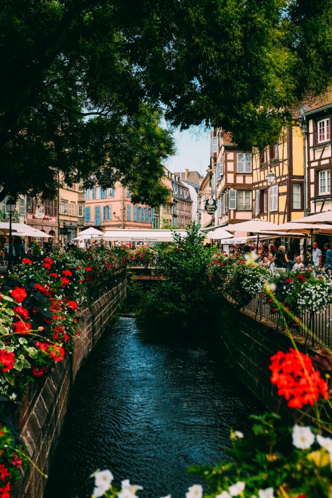 Scenic canal lined with flowers in Colmar’s La Petite Venise, featured in this Colmar travel guide."

