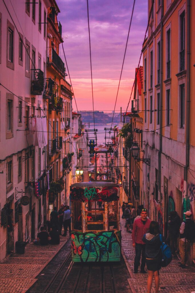 Lisbon street at sunset with a colorful tram, capturing the vibrant atmosphere of the city—perfect for Lisbon travel guide 2024.