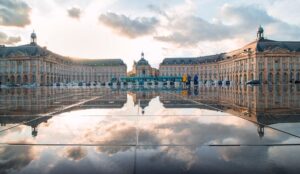 Breathtaking sunset reflection at Place de la Bourse, Bordeaux, France, showcasing historic architecture.