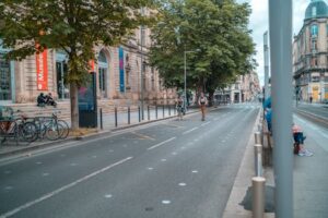 Urban street view of Bordeaux, France with people biking and walking.